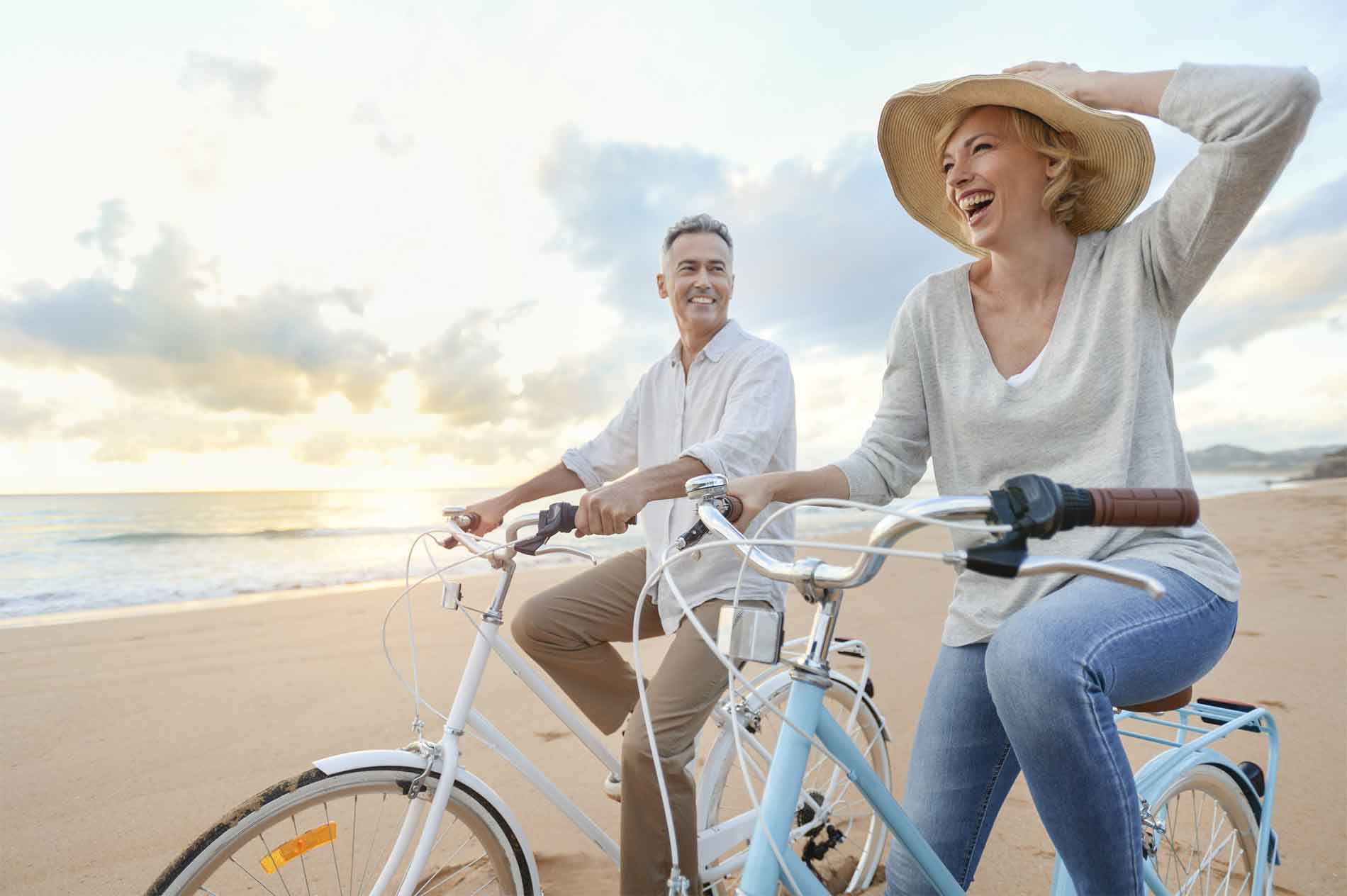 Couple riding bicycles on the beach